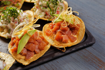 Tuna, shrimp and octopus toast snacks with radish, cucumber and avocado.