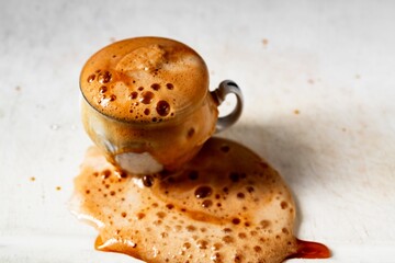Coffee is poured from a cup on the table.