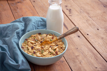 CEREAL BOWL AND MILK BOTTLE READY TO EAT ON RUSTIC WOODEN TABLE, HEALTHY FOOD CONCEPT.
