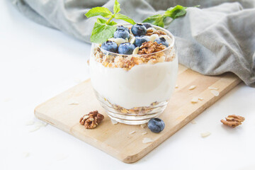 Healthy blueberry and walnut parfait in a glass on a white background