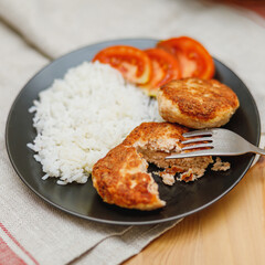 Plate with homemade salmon fish cutlets with rice on table