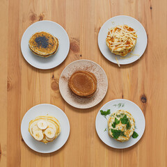 Stack of various pancakes on table, top view food flatlay