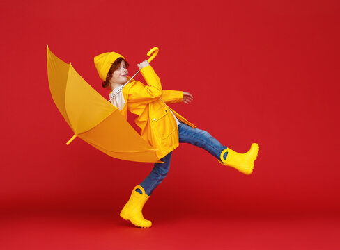 Cheerful boy walking with umbrella.
