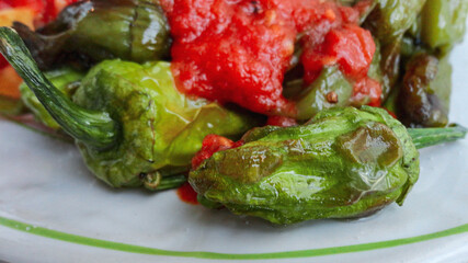 Fried green pepper covered with organic tomato sause in the white plate