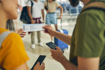 Man asking female about his boarding ticket in the airport