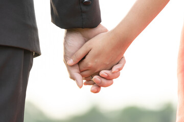 The hand of the bride and groom Holding hands in a manner that demonstrates love, warmth In the wedding ceremony