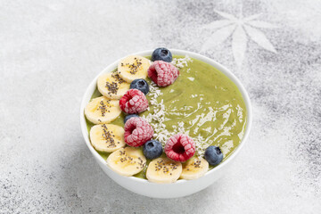 Healthy Breakfast smoothie in a bowl with hemp protein, avocado, banana, coconut, raspberries, blueberries and Chia seeds.