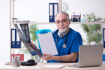 Old male doctor working in the clinic