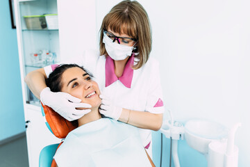 Dental examination of the patient. Dentist curing a woman patient in the dental office in a pleasant environment. Dentistry. Dental care. A woman treats her teeth at the dentist. Prevention of caries