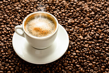 Cup with coffee on the background of coffee beans