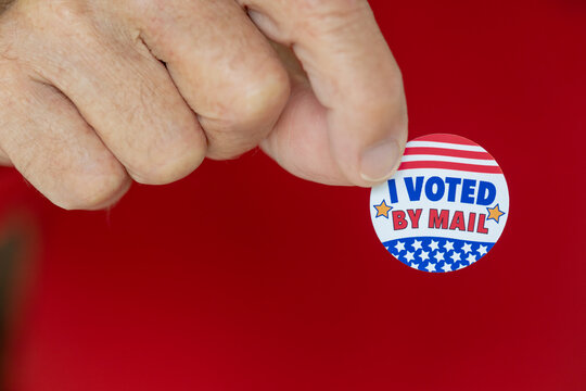 Older Man Holding I Voted By Mail Sticker, Close Up On Sticker