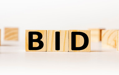 A wooden block with the word BID written on it on a white background. Business concept
