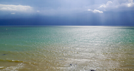 Rain Clouds Panorama at the 
emerald sea Horizon in the late afternoon. Blue waves, blue sky.