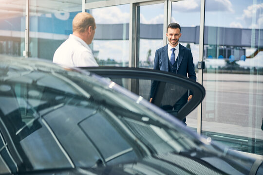 Cheerful Gentleman Walking Out Of The Airport Taking A Taxi