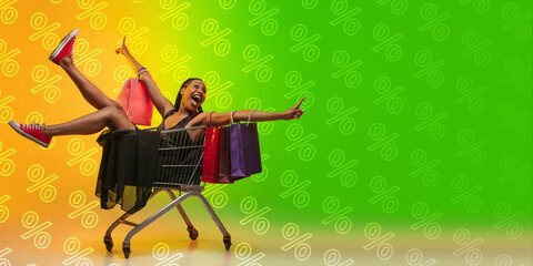 Crazy happy. Portrait of young beautiful woman in neon light on gradient studio backgound with...