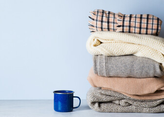 Winter cozy and casual clothes stack close up on on white background