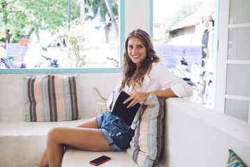 Serene female chilling in room and reading diary