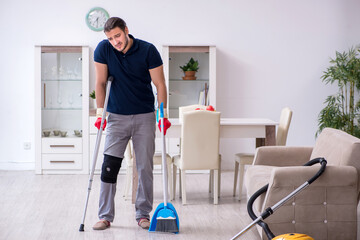 Fototapeta na wymiar Young leg injured contractor cleaning the house