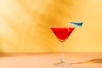 Vacation red cocktail  martini in glass with blue plane  on yellow background
