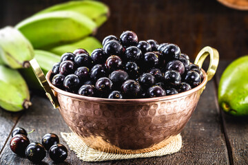 Jabuticaba. Brazilian and South American tropical fruits, in a copper pot on a rustic table