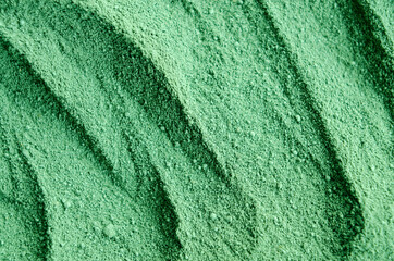 Green cosmetic clay powder (kelp facial mask, spirulina body wrap) texture close up, selective...