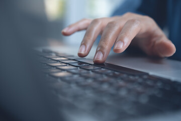 Close up of woman hand surfing the internet typing on laptop computer keyboard