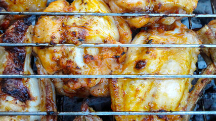 Chicken wings on barbecue grill with fire close up. Chicken meat on the grill