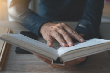 casual man reading a book on table