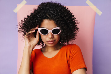 Image of african american woman in sunglasses looking at camera