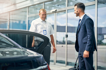 Cheerful driver meeting friendly businessman at the airport