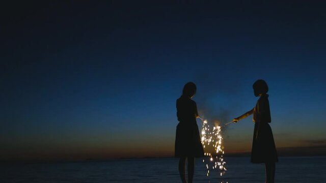 夕暮れに花火をする女子高生