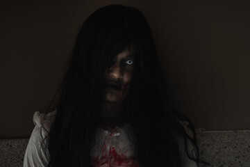 Girl zombie in blood. Closeup face and eyes of Asian Woman ghost with blood. Horror creepy scary...