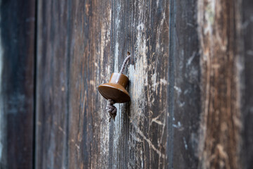 Vintage metal iron door handle on an old door made of natural wood. Horizontal orientation, selective focus. Doorknocker