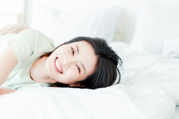 Asian women laughing in bed