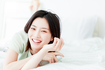 Asian women laughing in bed