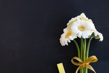 Teacher day concept. Bouquet of flowers, chalk on blackboard background. Top view, copy space