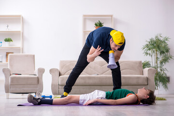 Father and son doing sport exercises indoors
