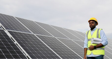Portrait of african american engineer on background field of photovoltaic solar panels. Black man...