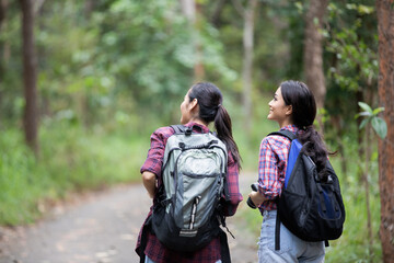 Asian Group of young people Hiking with friends backpacks walking together and looking map and taking photo camera by the road and looking happy ,Relax time on holiday concept travel