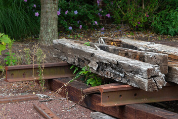 Old wooden railway sleepers rails and sleepers on the background of green grass
