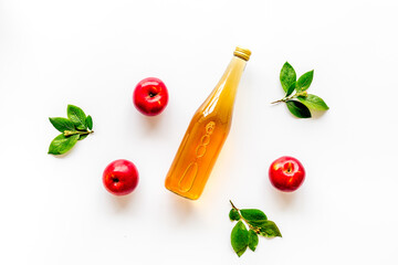 Bottle of vinegar with red apples. Top view, copy space