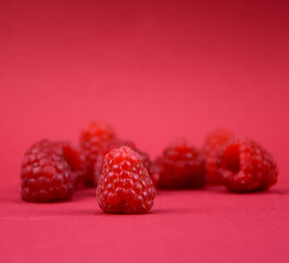 Ripe raspberries frame on a red background stock images. Raspberry berries isolated on a red background with copy space for text. Raspberry red border photo images