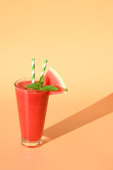 Watermelon smoothie with shadow on beige. Close up. Vertical format.