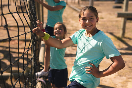 Portrait of girls net climbing during obstacle course at a boot camp