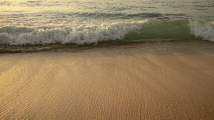 Scenic seascape. Milky foam waves at the beach. Sunset time. Waterscape for background. Selected soft art focus. Sunlight reflection on the water and sand. Balangan beach, Bali, Indonesia