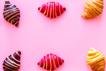 Frame of croissants - fresh bakery on pink background. Top view