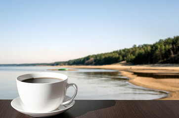 Cup of black coffee or tea against Baltic sea and beach background in Latvia