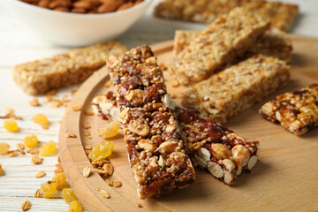 Tray with granola bars and bowl with almond on white wooden background