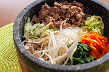 Delicioso e colorido prato coreano bibimbap montado em uma vasilha de pedra
