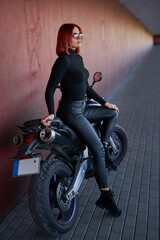 Fototapeta na wymiar Beautiful girl resting on the bridge with her motorcycle